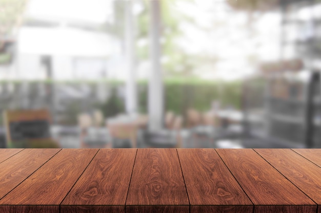 Mesa de madera en el fondo borroso de la moderna sala de restaurante o cafetería para maqueta de exhibición de productos