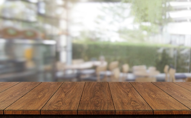 Mesa de madera en el fondo borroso de la moderna sala de restaurante o cafetería para maqueta de exhibición de productos.