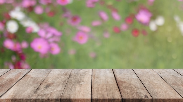 Mesa de madera y fondo de flores borrosa con filtro vintage