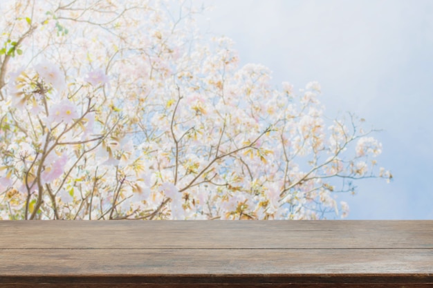 Foto mesa de madera y fondo de flores borrosa con filtro vintage