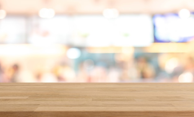 Mesa de madera y fondo interior de cocina de restaurante borrosa - se puede utilizar para mostrar o montar sus productos.