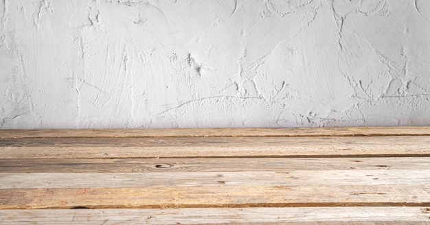 Mesa de madera frente a una pared rústica con espacio de copia vacío