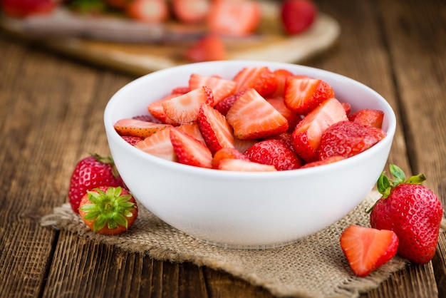 Mesa de madera con fresas picadas enfoque selectivo