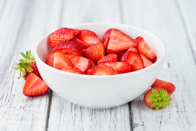 Mesa de madera con fresas picadas enfoque selectivo