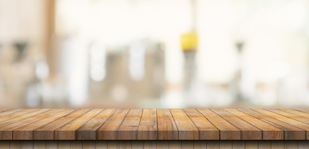 Mesa de madera con gente borrosa en la cafetería y fondo de café para montaje de exhibición, espacio de copia.