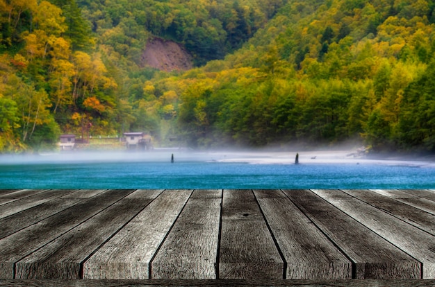 Mesa de madera gris vacía o terraza de madera con hermosa vista del estanque Taisho en el Parque Nacional Kamikochi en los Alpes del norte de Japón