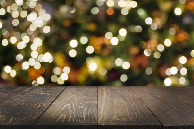 Foto mesa de madera y guirnalda borrosa.