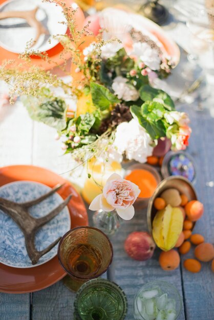 Mesa de madera hecha de tablones en la naturaleza con frutas y flores.