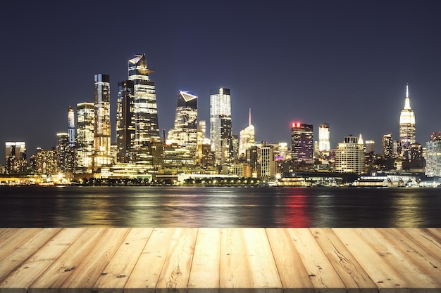 Mesa de madera con hermoso horizonte de Nueva York por la noche en maqueta de fondo