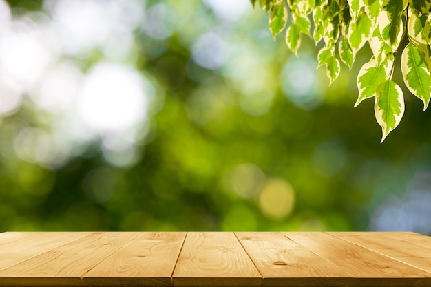 La mesa de madera con hojas en el fondo de la naturaleza y copia espacio para insertar texto.