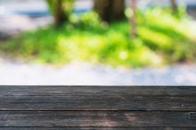 Mesa de madera en jardín borroso