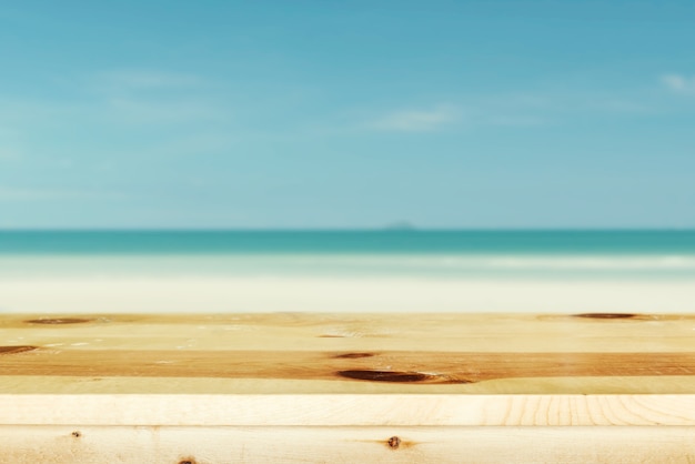 Mesa de madera en el mar azul borrosa