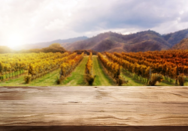 Mesa de madera marrón en otoño paisaje de viñedos con espacio vacío para exhibición de productos