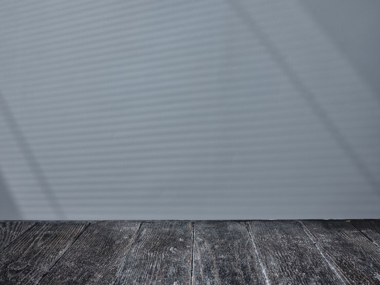 Foto mesa de madera negra con luz de persianas en el fondo