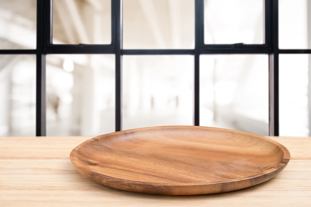 Mesa de madera en perspectiva y bandeja de madera en la parte superior sobre fondo de cafetería desenfoque