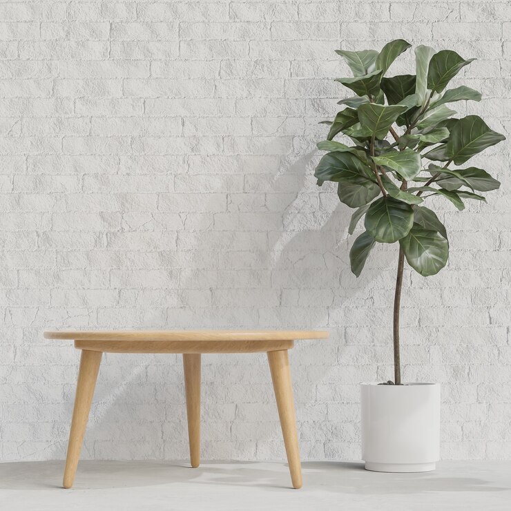 Mesa de madera con planta en pared de ladrillo blanco.