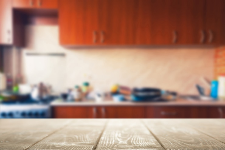 Foto mesa de madera para la presentación del producto sobre fondo de cocina borrosa