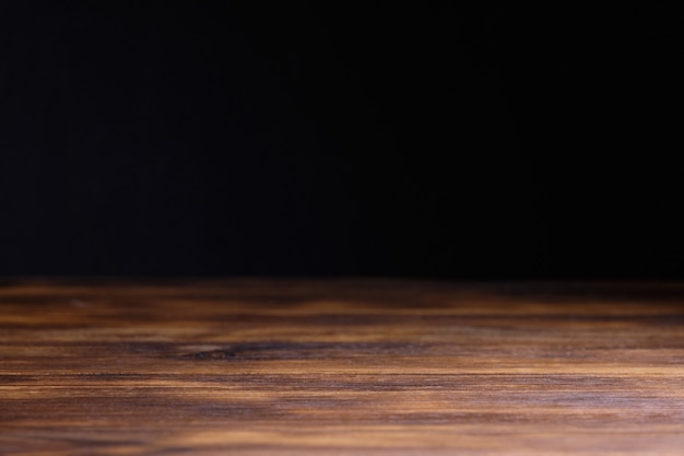 Mesa de madera quemada sobre fondo negro para publicidad