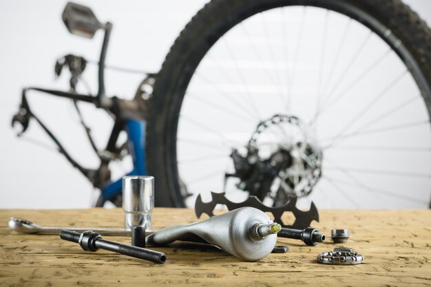 Mesa de madera con repuestos para bicicleta de montaña.