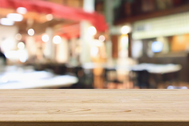 Mesa de madera con restaurante cafetería borrosa abstracta con luces bokeh de fondo desenfocado