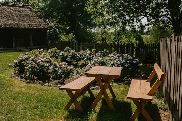 Foto mesa de madera con sillas en el jardín.