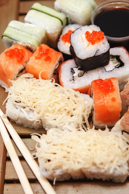 En una mesa de madera se sirven varios tipos de rollos. Menú de sushi para la cocina japonesa.