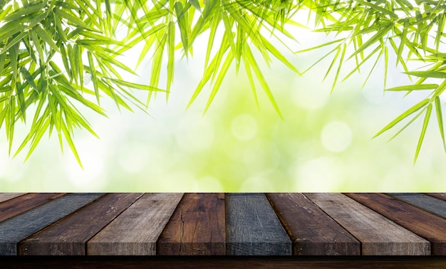Mesa de madera sobre hojas de bambú con luz natural en un fondo borroso