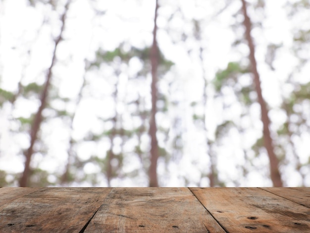 Mesa de madera sobre pinos borrosos en el bosque de invierno