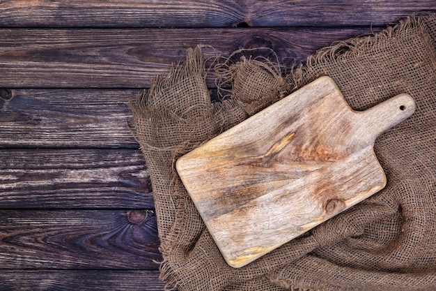 Mesa de madera con tela de arpillera y tabla de cortar.