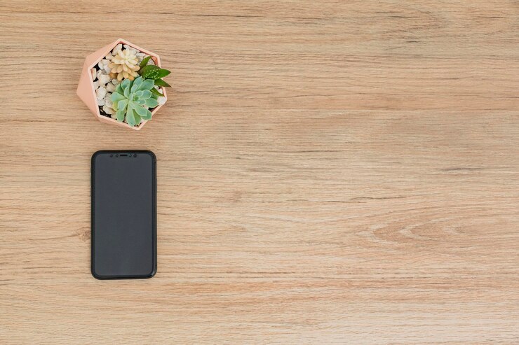 Foto una mesa de madera con un teléfono y suculentas encima.