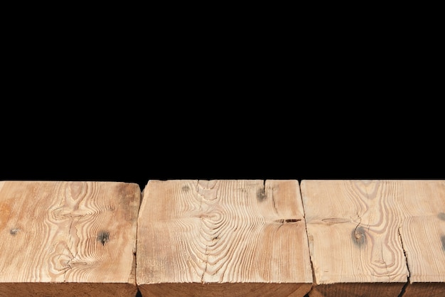 Mesa de madera con textura vieja vacía sobre un fondo negro para mostrar y montar sus productos y cosas. Se utilizó el apilamiento de enfoque para crear una profundidad de campo completa.
