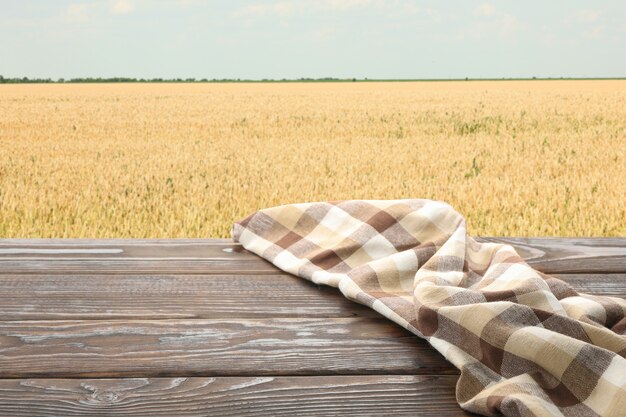 Mesa de madera con toalla contra el campo. Concepto de agricultura