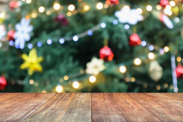 Mesa de madera vacía con árbol de Navidad borroso con fondo claro de bokeh