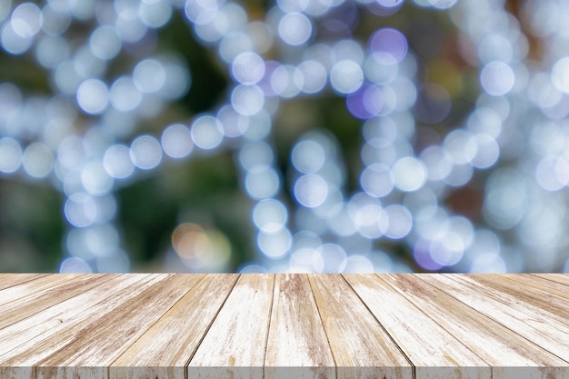 Mesa de madera vacía con árbol de Navidad borroso con fondo claro de bokeh