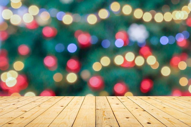 Mesa de madera vacía con árbol de Navidad borroso con fondo claro de bokeh