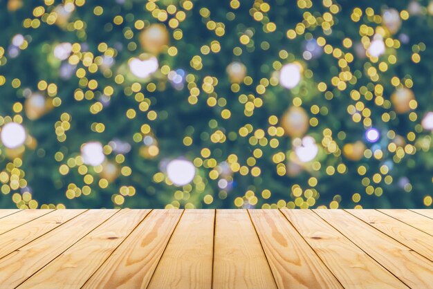 Mesa de madera vacía con árbol de Navidad borroso con fondo claro de bokeh
