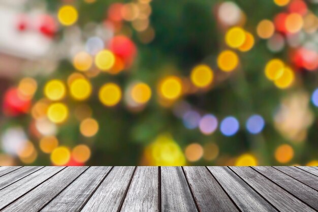 Foto mesa de madera vacía con árbol de navidad borroso con fondo claro bokeh