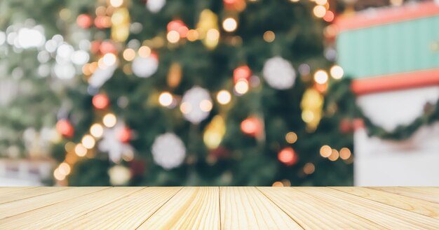 Mesa de madera vacía con árbol de Navidad de desenfoque abstracto con fondo claro de decoración bokeh para exhibición de productos