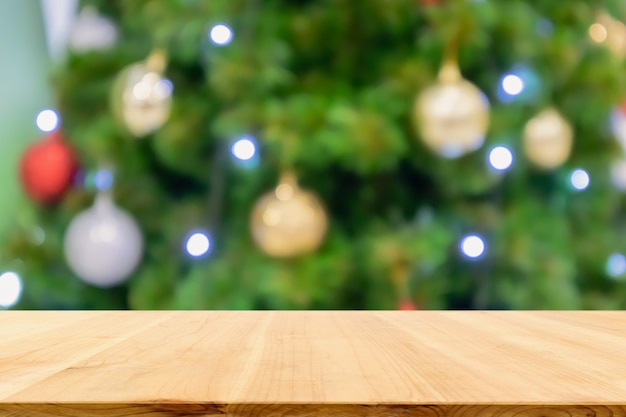 Mesa de madera vacía con árbol de Navidad de desenfoque abstracto con fondo claro de decoración bokeh para exhibición de productos