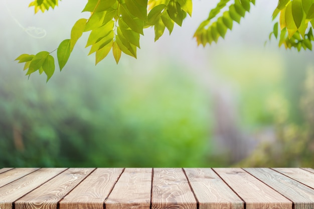 Foto mesa de madera vacía y árbol verde borroso