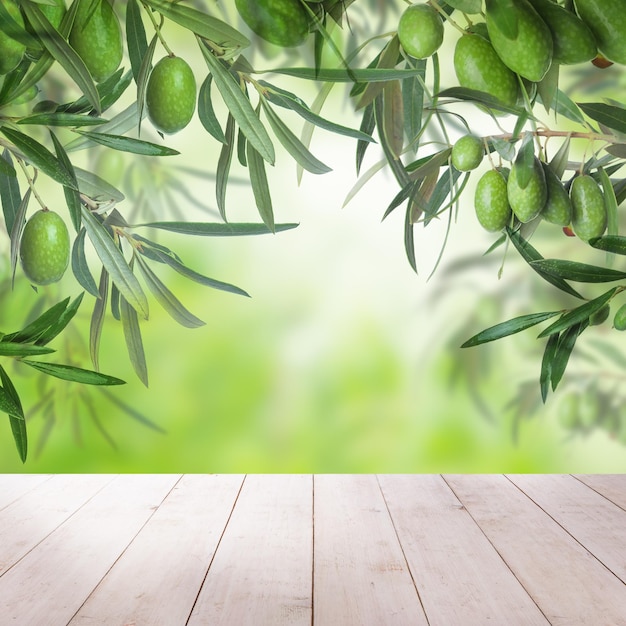 Mesa de madera vacía blanca aceitunas verdes frutas y hojas luz bokeh abstracta y sobre fondo verde Espacio de copia de fondo de alimentos