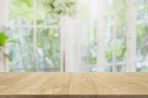 Mesa de madera vacía y borrosa de la habitación interior con vista a la ventana