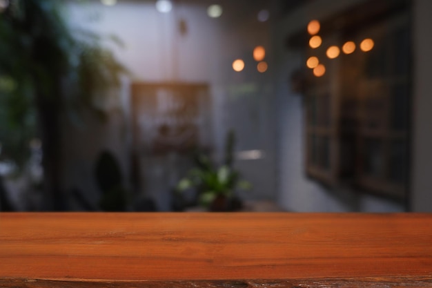 Mesa de madera vacía delante del interior de la casa restaurante Cafe borrosa abstracta para montaje produc