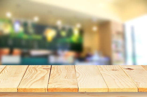 Mesa de madera vacía con desenfoque de cafetería con fondo bokeh