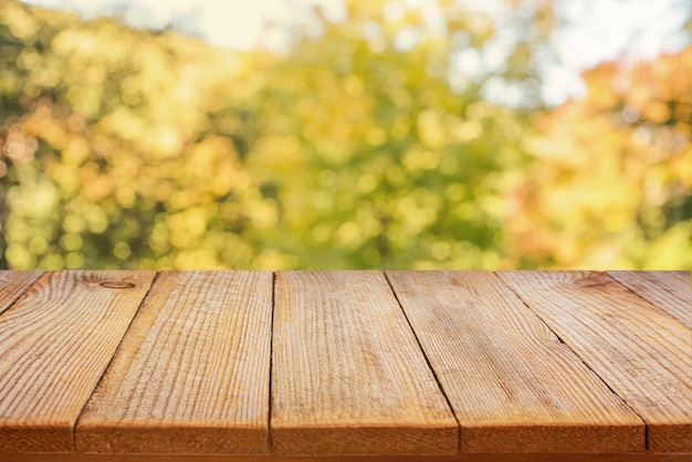 Mesa de madera vacía y fondo abstracto de otoño