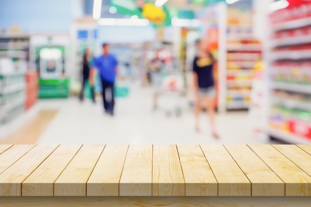 Mesa de madera vacía con fondo borroso de supermercado para la exhibición de productos