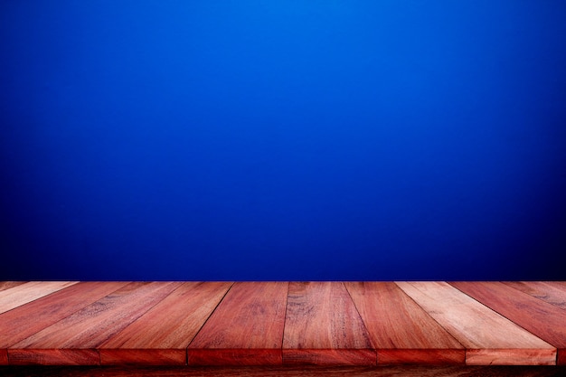 Mesa de madera vacía con fondo de textura de pared azul