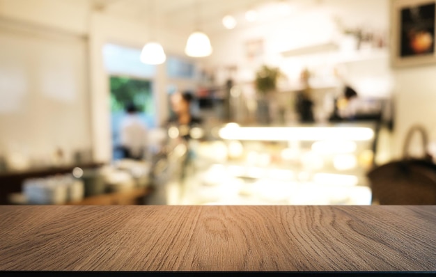 La mesa de madera vacía frente al fondo borroso abstracto de la cafetería se puede usar para exhibir o montar sus productos Maqueta para exhibir el producto