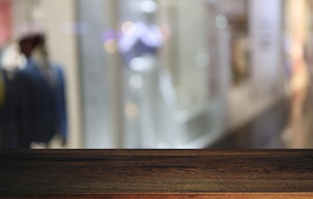 La mesa de madera vacía frente al fondo borroso abstracto de la cafetería se puede usar para exhibir o montar sus productos Maqueta para exhibir el producto