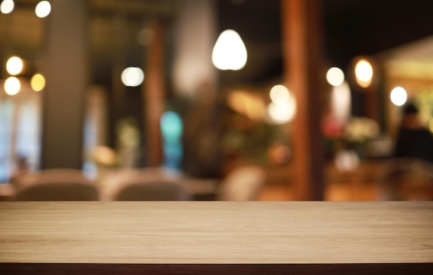 La mesa de madera vacía frente al fondo borroso abstracto de la cafetería se puede usar para exhibir o montar sus productos Maqueta para exhibir el producto